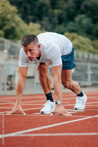 Fit, active man stands on a marked start line, ready to begin a workout