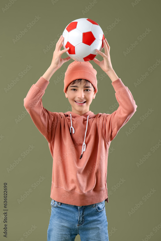 Fototapeta premium Little boy with soccer ball on color background