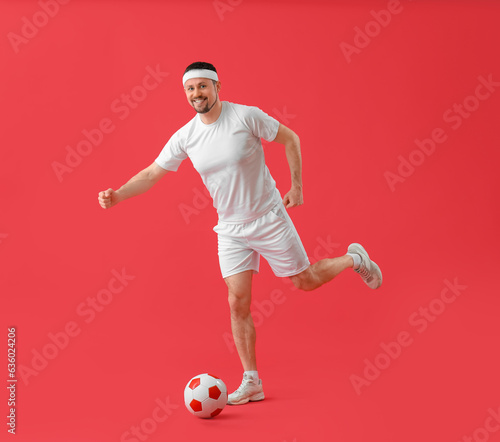 Fototapeta Naklejka Na Ścianę i Meble -  Man playing soccer on red background