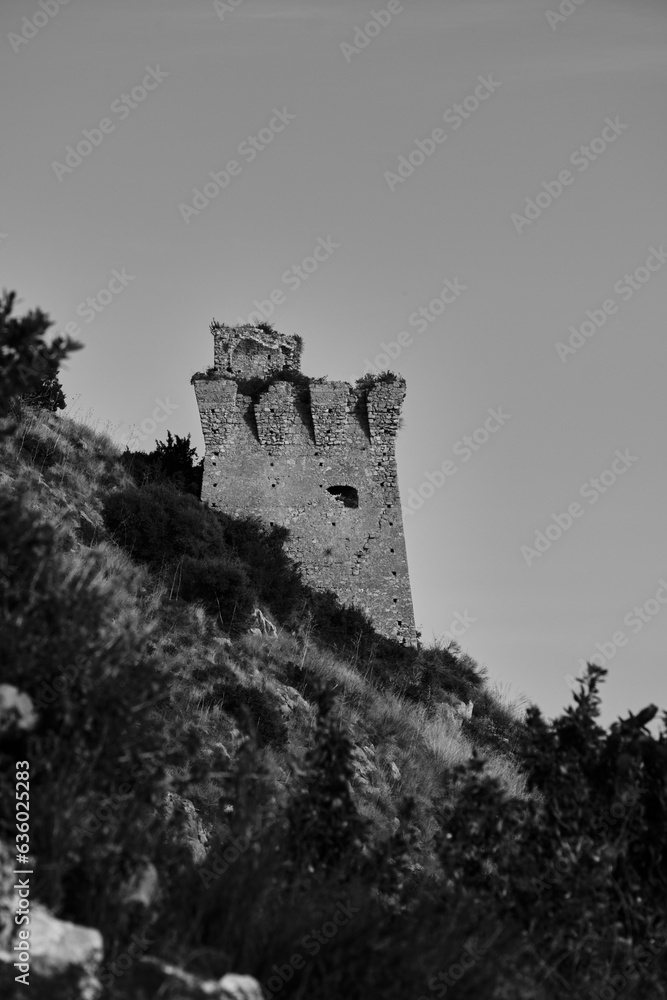 Obraz premium Vertical of an old castle on a hill in South Italy in grayscale