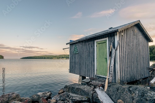 Scenic view of wooden houses on shore of a lake at sunset © Photokrisan/Wirestock Creators