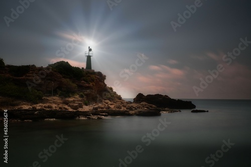 a lighthouse sitting on top of a cliff by the water