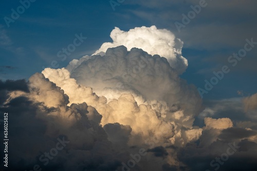 Scenic view of thunderstorm building cumulus clouds with orange sunlight in the Austrian Alps.
