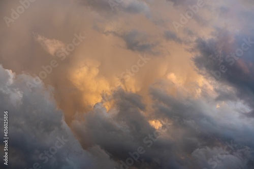 Scenic view of thunderstorm building cumulus clouds with orange sunlight in the Austrian Alps.