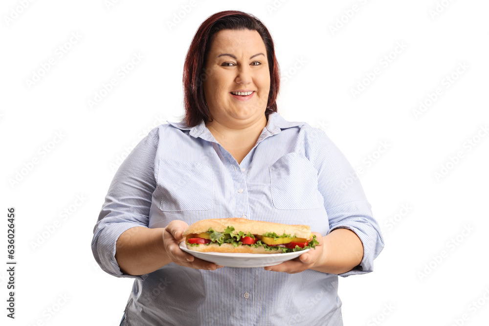 Overweight woman holding a sandwich on a plate and smiling