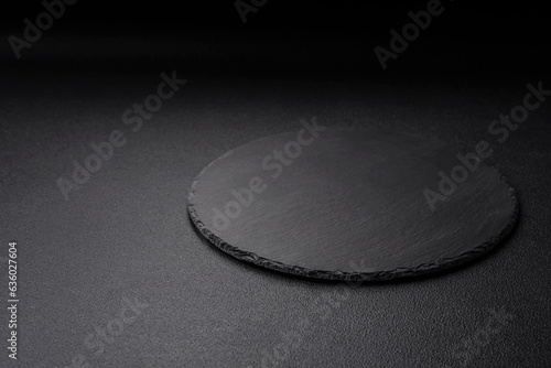 Empty black plate over dark stone background with copy space