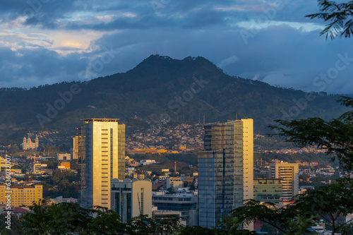 a beautiful sunset light illuminating the presidential office buildings in Tegucigalpa, with a dark sky as background