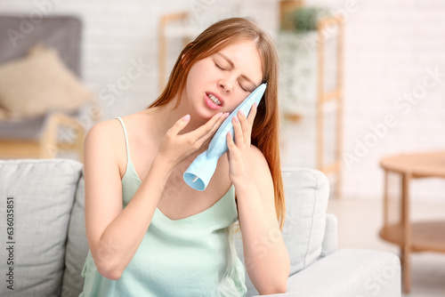 Obraz na plátně Young woman with tooth ache holding cold compress at home