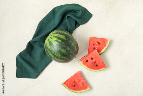 Whole ripe watermelon and pieces on light background photo