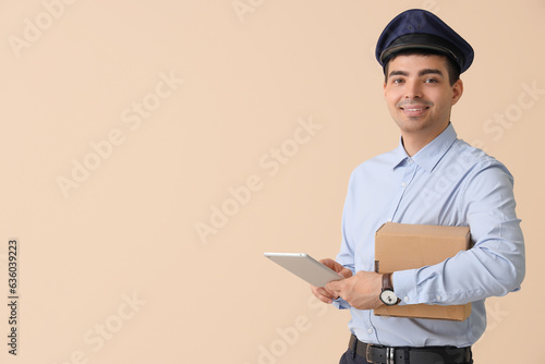Young postman with tablet c...