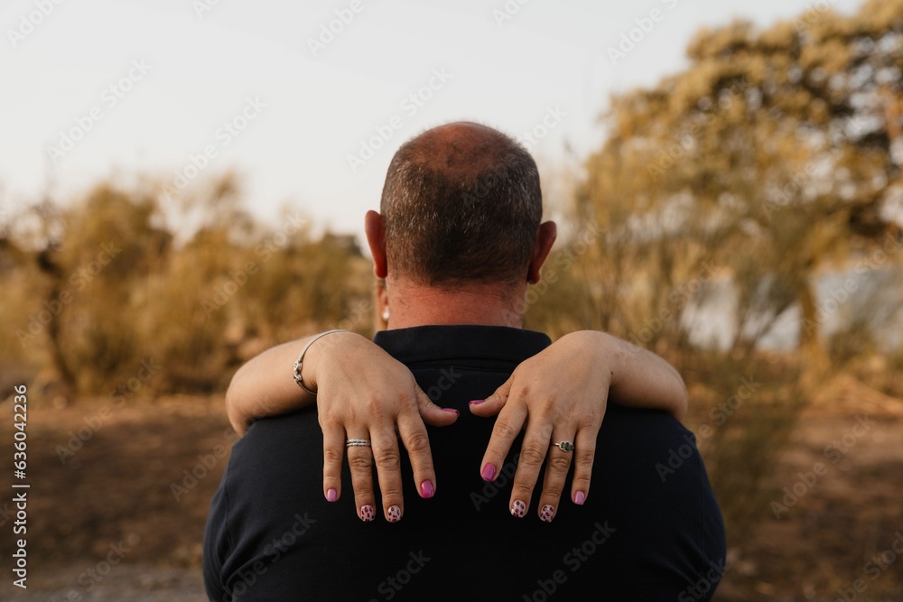 two people with hand on each other's shoulders facing away from camera two people with hand on each other's shoulders facing away from camera