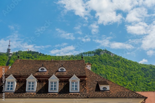 Scenic view of houses in Brasov, Romania against green mountains