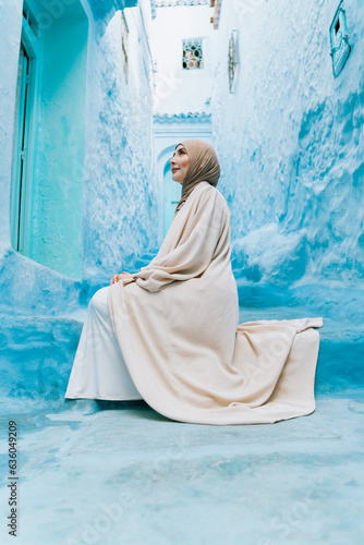 Serene toughtful muslim woman on a blue street photo