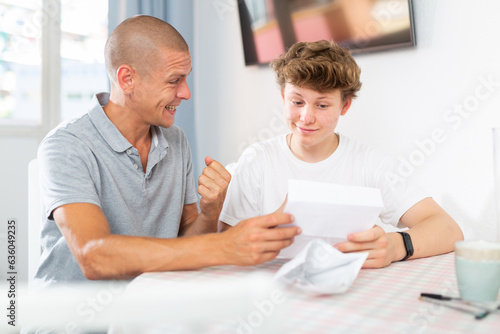 Father and son have recieved letter and reading it. They feeling happy because letter contains good news.