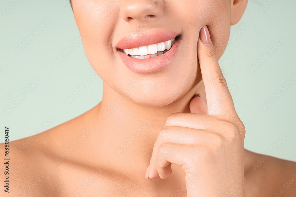 Obraz premium Young woman with beautiful lips on green background, closeup