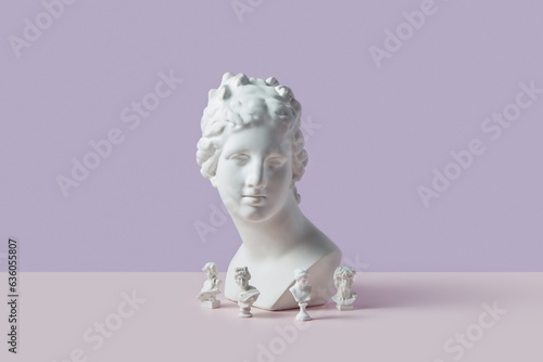 Big plaster Greek goddess bust surrounded by tiny statues. photo