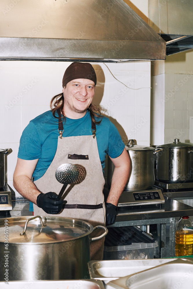 cook holding a saucepan in his hand cook holding a saucepan in his hand