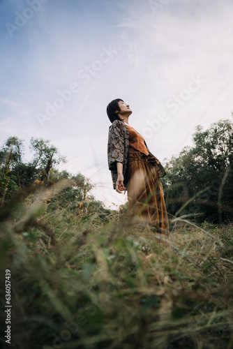 Cultural Elegance: Stylish Woman Embracing Tradition in Woodland Dance photo