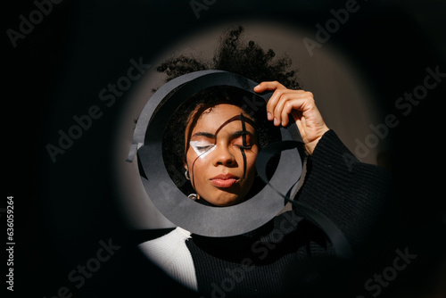 Black female model through round shaped frame photo