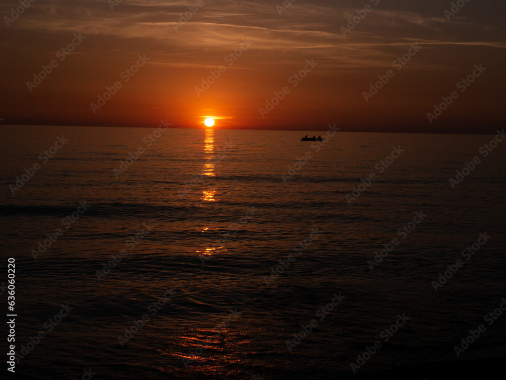 Sunset in Italy Toskana at mittelmeer with fishing boat in the water and small Waves Dawn