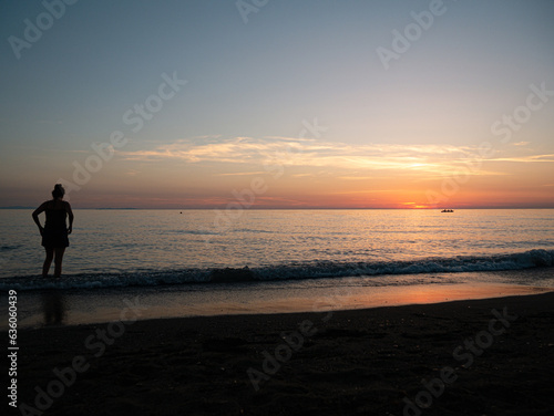 Person Boy Girl looking at horizon during sunset in italy at the mittelmeer Sea Enjoy dawn at mare