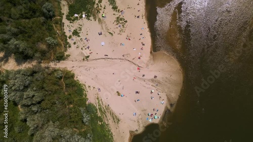Many people sunbathing on sandy beach and swimming in Vistula River close to the Anna Jagiellon Bridge, Warsaw. A small amount of water in the river. Water shortage. Unguarded beach. 4K 59.94 fps photo