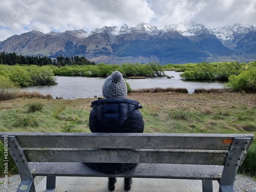 Enjoying the beautiful view of the lake and mountains from a bench photo