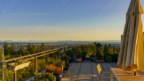 Rooftop patio with forever views across valley to distant islands in ocean, bathed in glow of setting sun. © Andrew