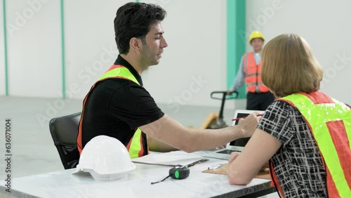 Professional male factory engineer working on computer screen with female manager in factory