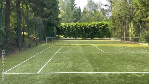 Wallpaper Mural A grass tennis court in the middle of green trees and a sunny day. Grass covering of the sports field. Playing tennis. Torontodigital.ca