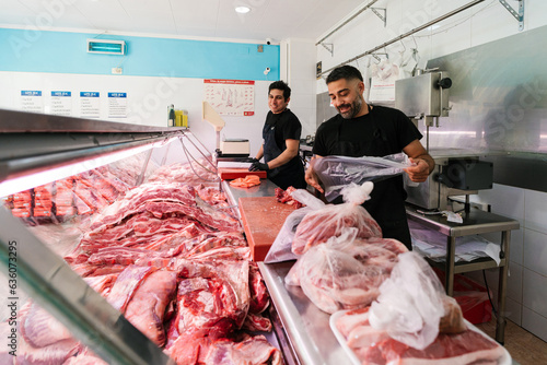 Smiling sellers working with raw meat photo