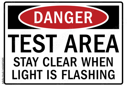 Testing in progress warning sign and labels test area. stay clear when light is flashing
