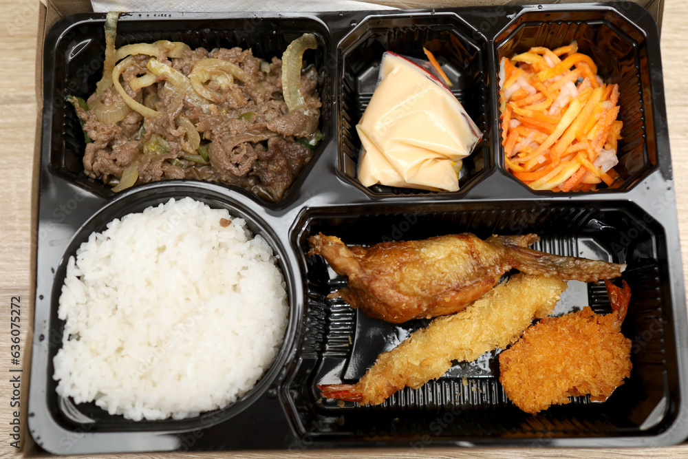 bento box with sushi, rolls, rice, chicken, beef, shrimp, pork, lunch
