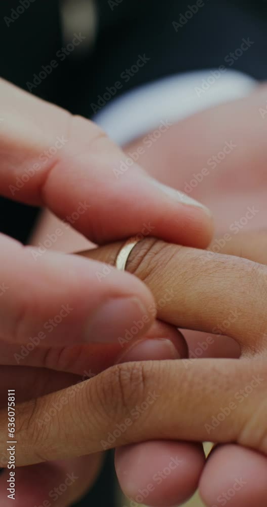The groom puts a ring on the bride's finger, standing outdoor, close-up of hands The groom puts a ring on the bride's finger, standing outdoor, close-up of hands