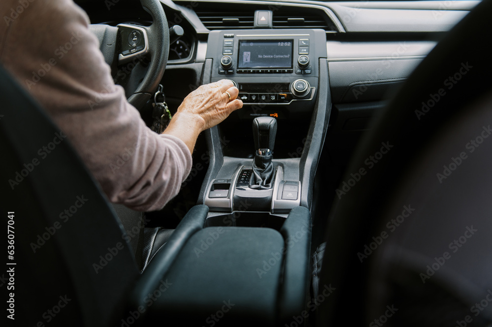 middle aged woman inside a car pushing button middle aged woman inside a car pushing button