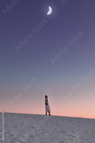 Woman in the desert under a dramatic moon photo