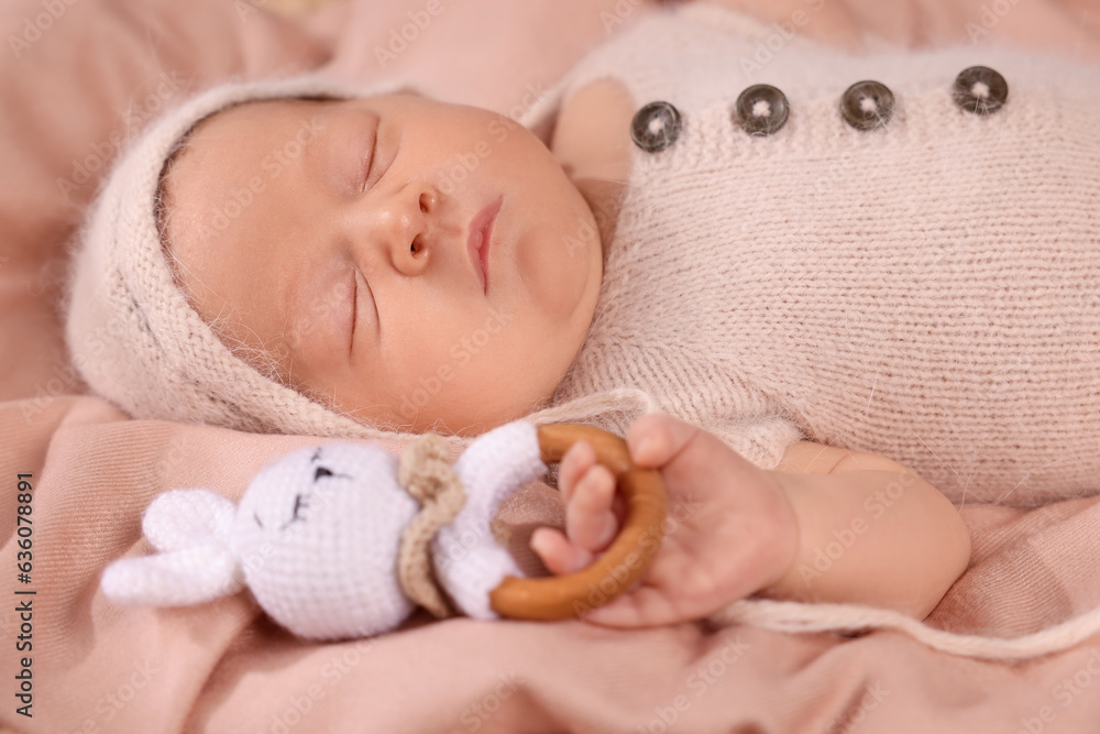 Cute newborn baby sleeping with rattle on blanket, closeup Cute newborn baby sleeping with rattle on blanket, closeup