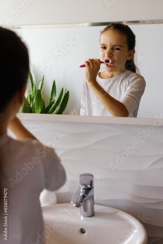 Preteen bathroom brushing teeth habit reflection photo