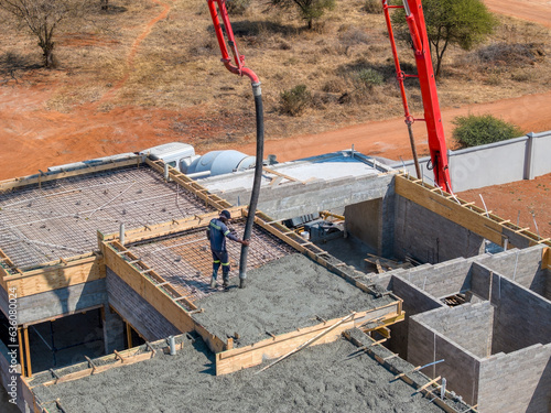 Фотография african construction workers in town at the construction site using a boom concr