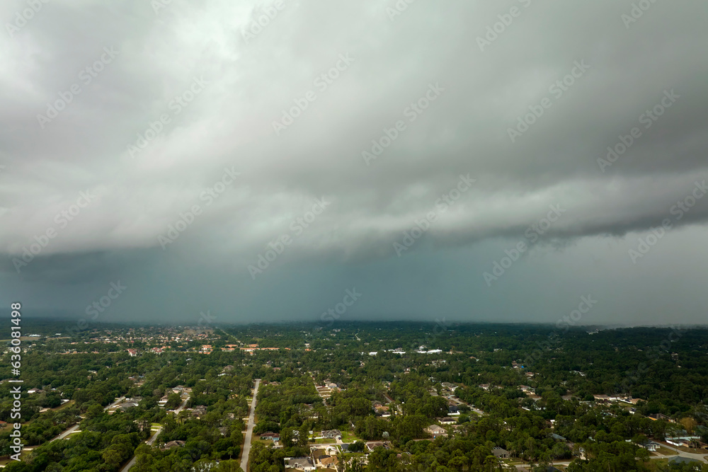 Landscape of dark ominous clouds forming on stormy sky before heavy thunderstorm over rural town area