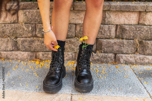 unrecognizable teenager putting flowers inside her boots