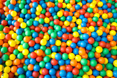 Child hidden among thousands of colored balls photo