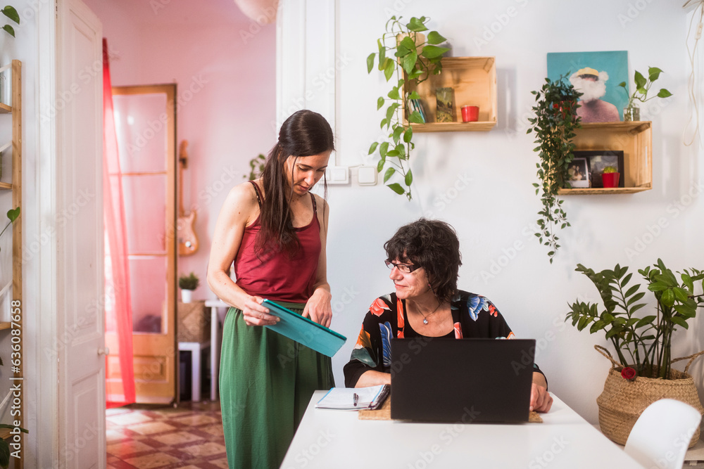 Multigenerational women using laptop and tablet at home Multigenerational women using laptop and tablet at home