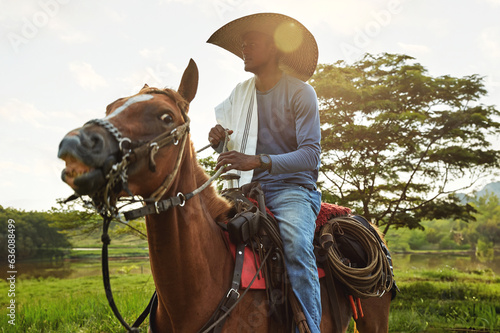 Smiling cowboy portrayed riding on his horse on a Colombian farm photo