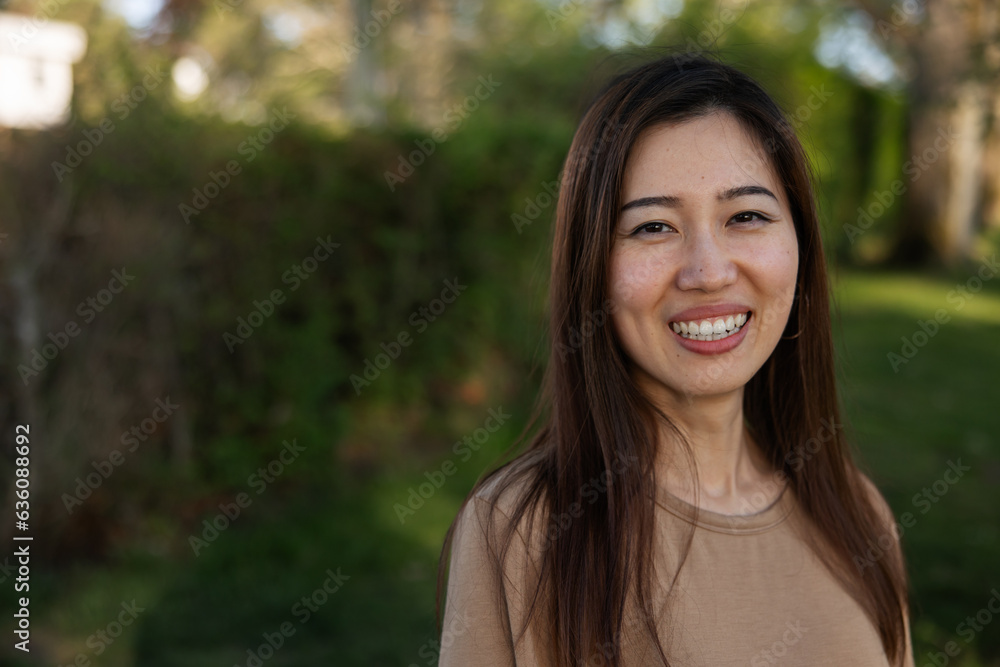 Happily smiling woman in front of a tree, showing teeth. Happily smiling woman in front of a tree, showing teeth.