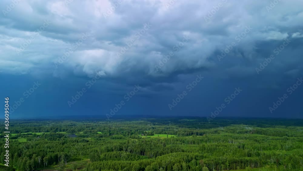 Dark rain storm clouds flowing above woodland landscape, aerial drone view Dark rain storm clouds flowing above woodland landscape, aerial drone view