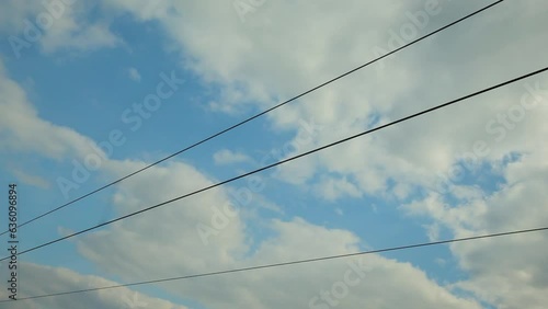 Wallpaper Mural Low angle view of a gray pole and intricate network of black power lines silhouetted against a vibrant blue sky speckled with white clouds Torontodigital.ca
