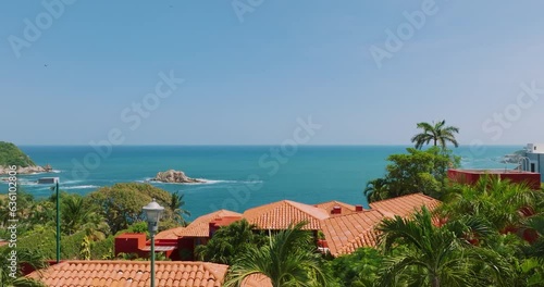 Vista de dron aérea  dolly in hacia el mar en bahía conejos huatulco. Video 4k