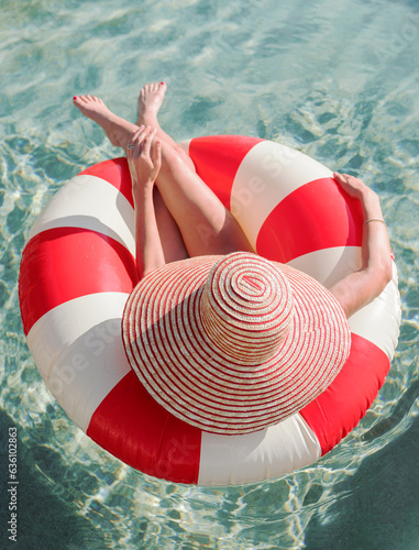 woman relaxing in pool with sunhat photo