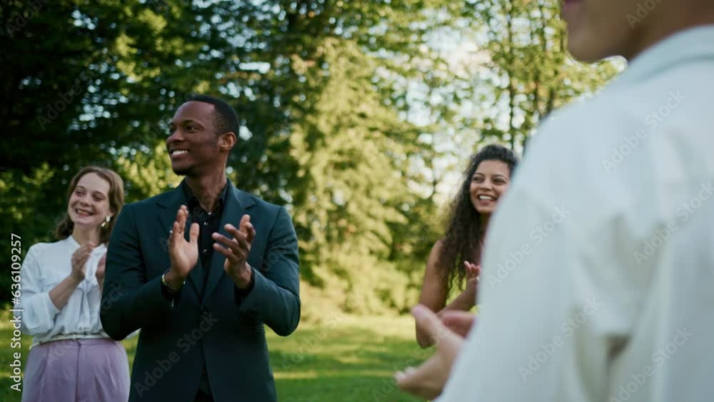 The groom walks past the applauding guests at an outdoor wedding